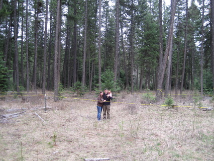 Lance and Lorinda standing on the future building site of the farmhouse in Idaho in the forest
